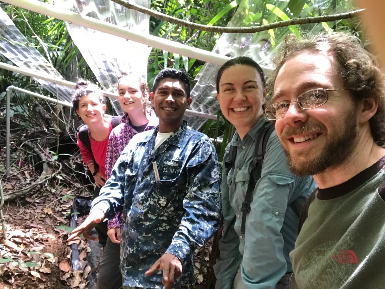 A group of five people pose for a selfie and smile at the camera in a tropical forest in Panama